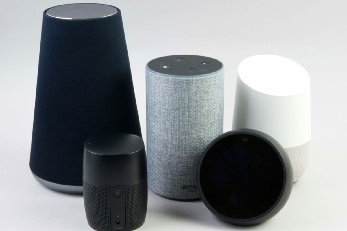 Amazon Echo、Google Nest、HomePodのスマートスピーカー3機種を木製テーブルに並べて比較。形状や色の違いがわかる。